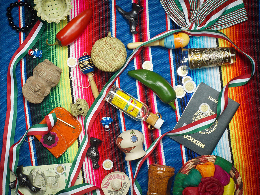 Mexican theme items strewn on colorful blanket