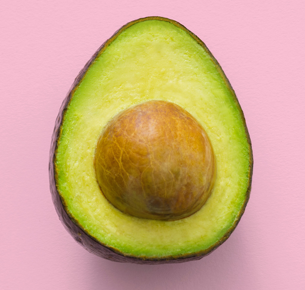 closeup of a halved avacado with pit inside